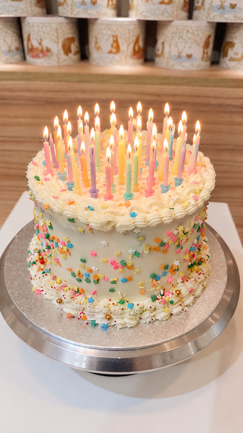 Tarta de vainilla con dulce de leche, decorada con grajeas de colores.