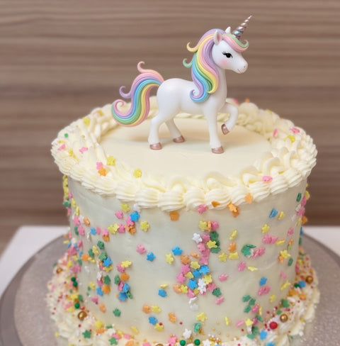 Tarta de vainilla con dulce de leche, decorada con grajeas de colores.